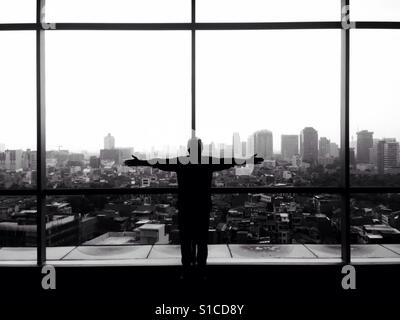 Silhouette di uomo alzare le mani con il paesaggio sullo sfondo del paesaggio - bianco e nero Foto Stock