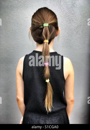 Ragazza di fronte a un muro grigio. Foto Stock