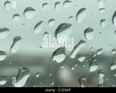Gocce di pioggia sulla finestra di auto in un giorno di pioggia Foto Stock
