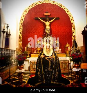 Una immagine della Vergine Maria e Gesù Cristo crocifisso decora un altare in Prado del Rey, Sierra de Cadice, Andalusia, Spagna Foto Stock