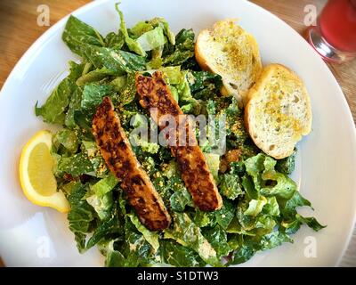 Una Caesar salad con tempeh bacon. Foto Stock