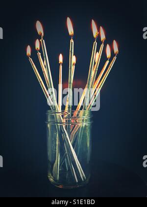 Candele accese in un vaso. Foto Stock