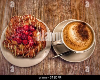 Il Cappuccino e lampone torta sul tavolo Foto Stock