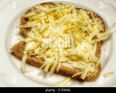 Formaggio Cheddar grattugiato su Hovis ha agile di pane integrale Foto Stock