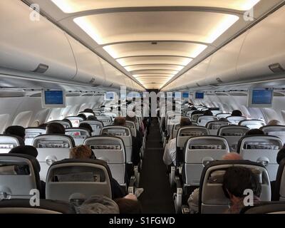 A bordo di un aereo di linea. Vista del corridoio dalla parte posteriore di un aereo di passeggero Foto Stock