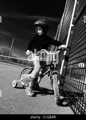 Ragazzo Bicicletta Equitazione con stabilizzatori Foto Stock