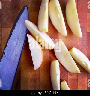 Un coltello e taglio fresco fette di mela su un legno tagliere Foto Stock