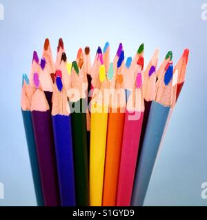 Un gruppo di affilatura colorate matite contro uno sfondo blu Foto Stock