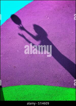 L'ombra di un bambino che è appena circa per la cattura di una sfera, viene catturato sullo sfondo del colorato pavimento morbido di un bambino giochi per bambini. Un'immagine con multi usi. Foto © COLIN HOSKINS. Foto Stock