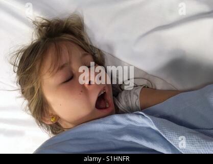 Bambino a sbadigliare nel suo letto. Foto Stock