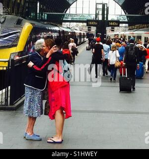 Addio abbraccio immagine dalla madre e figlia, presso la stazione di kings cross, London, Regno Unito Foto Stock