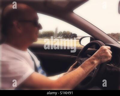 Uomo di mezza età la guida guida a sinistra auto, Canada Foto Stock