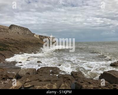 Porthcawl, Galles - 31 Luglio 2017: la marea sul giro inizia a lavare fino contro la parete del porto Foto Stock