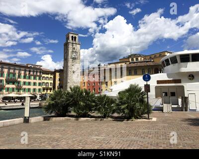 Riva del Garda sul Lago di Garda, Italy-May 2017: un traghetto è ormeggiata in banchina nel piccolo porto di fronte a piazza della città Foto Stock