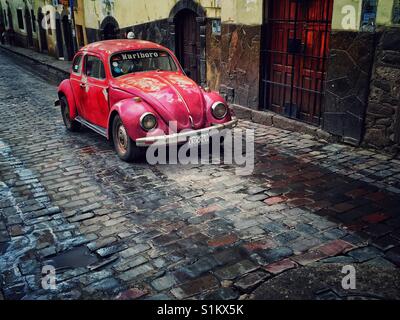 Vintage red rusty Volkswagen bug sulle strade di Cusco in Perù Foto Stock