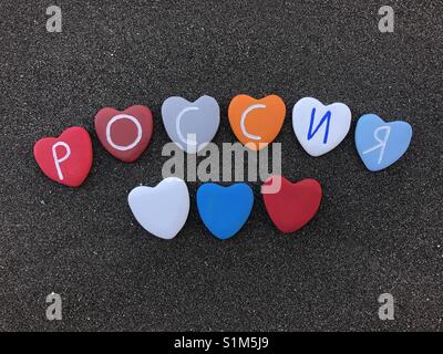 Россия, Russia, nome del paese con cuore colorato pietre su sabbia nera vulcanica Foto Stock