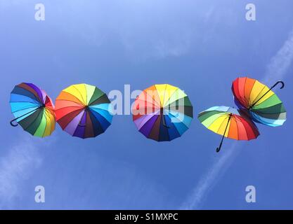 Ombrelloni colorati fluttuante nel cielo blu Foto Stock