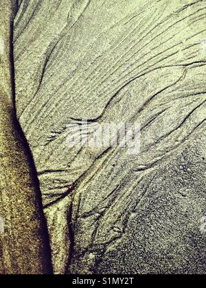 Paesaggio Astratto. Close up di modelli di acqua nella sabbia formando valli e dare impressione di deserto arido antenna. Foto Stock