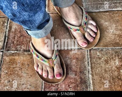 Donna in piedi da flipflops Fatface, ad alto angolo di visione Foto Stock