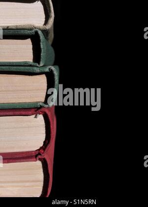 Immagine ravvicinata della pila di libri contro uno sfondo scuro. Foto Stock