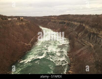 Il Grado 6 rapide sul fiume Niagara appena sotto le cascate in forma il confine con il Canada sulla sinistra e gli Stati Uniti sulla destra Foto Stock