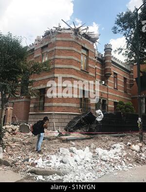 Un fotografo prende le immagini di un edificio danneggiato dopo un terremoto nella Colonia Roma, Città del Messico, Messico Foto Stock