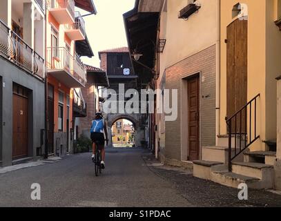 Una donna ciclista corsa ciclistica vecchia città medievale in Italia Foto Stock