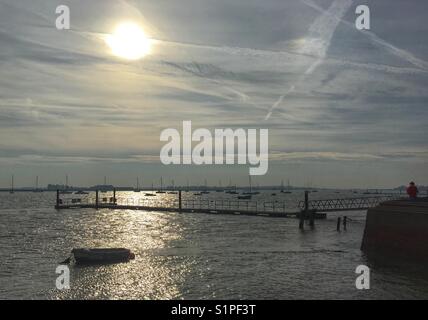 Nel tardo pomeriggio a Burnham on Crouch , Essex, con sole scintillante sull'acqua e yacht al di ancoraggio. Foto Stock