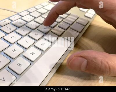 Mano d'uomo utilizzando la tastiera del computer. Chiudere la vista. Foto Stock