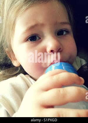 Bimbo che beve da una bottiglia Foto Stock