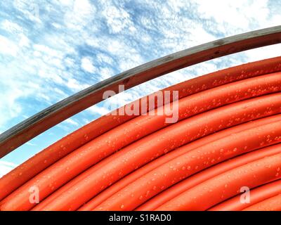 Abstract colpo di un arancio pipe roll con gocce di pioggia Foto Stock