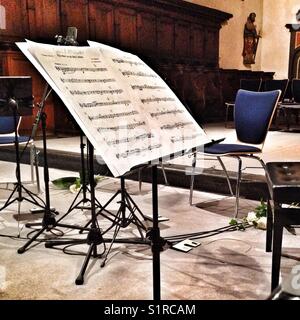 Fogli di musica su un cavalletto in una chiesa. Foto Stock