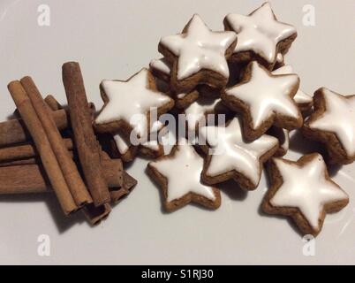 A forma di stella cannella i cookie su bianco tavolo da cucina e bastoncini di cannella Foto Stock