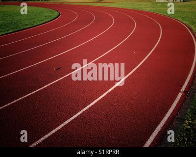 Tappeto erboso rosso con righe bianche su una via campo presso la scuola stadium Foto Stock