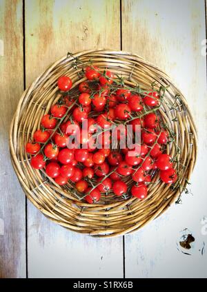 Pomodori ciliegini su un vassoio di vimini Foto Stock