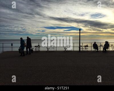 La gente a piedi lungo la passeggiata di Seaton beach nel Devon, in Inghilterra il 13 novembre 2017 Foto Stock