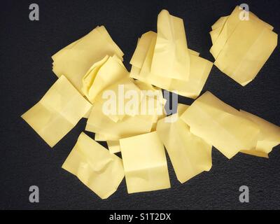 Un mucchio di note adesive su una superficie nera Foto Stock