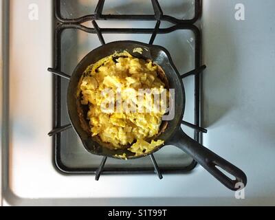 Uova strapazzate Prima colazione in una ghisa pan Foto Stock