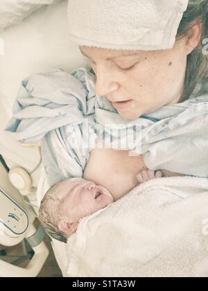 Immagine reale della nuova madre con appena nato il neonato sul petto immediatamente dopo il parto Foto Stock