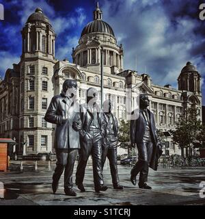 La statua dei Beatles e il porto di Liverpool edificio in background- Liverpool, Merseyside, Regno Unito Foto Stock