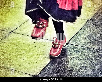 Intasare dancing, un tradizionale English Folk Dance, dettaglio di gambe & rosso zoccoli con campane. Prestazioni all'aperto a Sherborne, Dorset, Inghilterra, Foto Stock