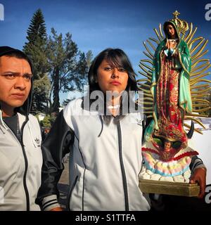Un pellegrino trattiene una immagine di Nostra Signora di Guadalupe durante il pellegrinaggio annuale a Nuestra Señora de Guadalupe Basilica di Città del Messico, Messico Foto Stock