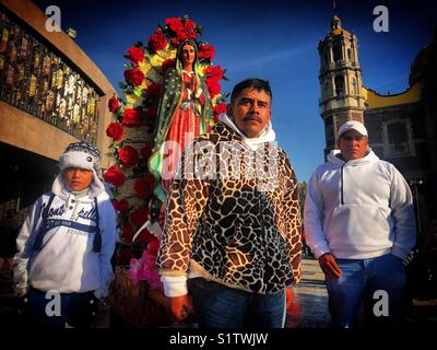 I pellegrini portano un immagine della Vergine di Guadalupe durante l'annuale pellegrinaggio alla Madonna della basilica di Guadalupe a Città del Messico Foto Stock