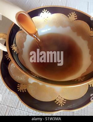 Il caffè che viene versato di una Cina POT del caffè in una tazza cinese Foto Stock