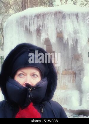 Senior donna bundled fino contro il freddo nel ciclone bomba blizzard, gennaio 2018, New York City Foto Stock