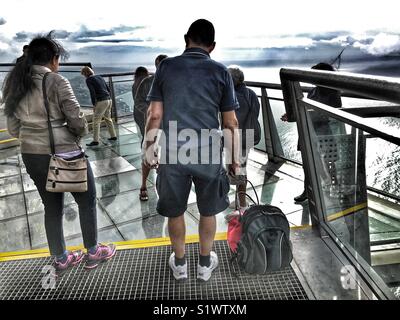 Persone in piedi sul vetro skywalk piattaforma di visualizzazione 580m sopra il mare, Miradouro do Cabo Girao, Madeira, Portogallo Foto Stock