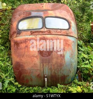 Il finestrino posteriore e il tronco di un vecchio arrugginito Volvo Cars in un cimitero di auto in Båstnäs, Dalsland, Svezia, Scandinavia, Europa Foto Stock