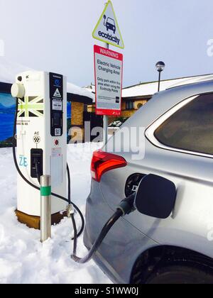 Collegare il veicolo ibrido Mitsubishi Outlander PHEV collegato a una stazione di ricarica Gridserve EV tramite un cavo CHAdeMO nella neve Foto Stock