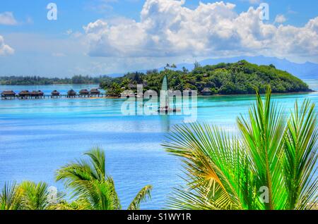 In barca a vela sulla laguna di Bora-Bora, Polinesia francese. Isola della suoneria in background. Foto Stock