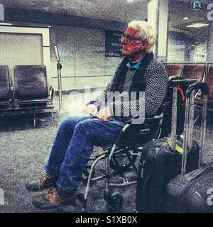 Senior uomo in sedia a rotelle in attesa in area dedicata per i passeggeri che necessitano di assistenza a bordo dell'aereo, l'aeroporto di Bristol, Inghilterra Foto Stock